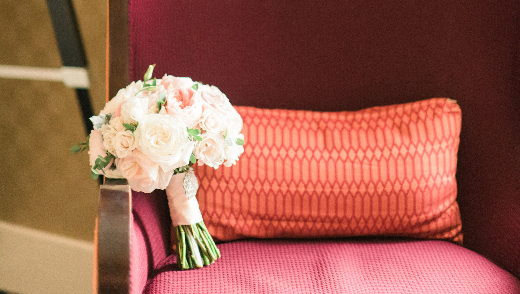 A bride's wedding bouquet rests on the arm of the suite's seating area.